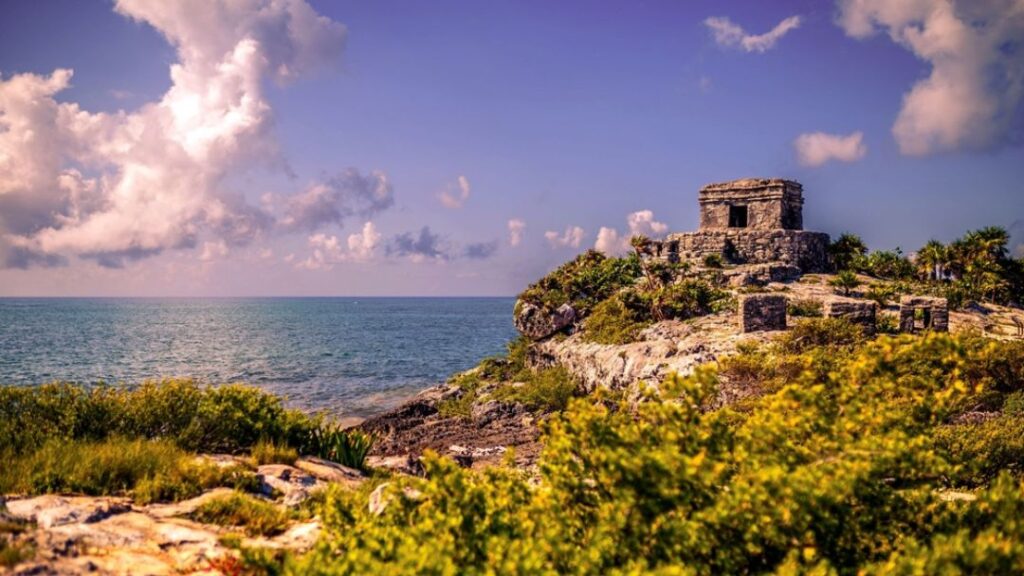 Tulum's ancient Mayan ruins overlooking turquoise Caribbean Sea, representing destination travelers reach from Cancun Airport via various transportation options